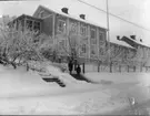 Brahegatan 20 i vinterskrud. Två barn står på trappan från gatan upp till huset.