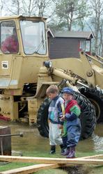 Flom-bilder. To små gutter og stor laster