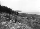 Utsikt från södra delen av Grännaberget mot sydväst. Vägen söderut till Röttle by skär genom åkermarken. Röttle kraftstation syns nere vid Vättern strand.