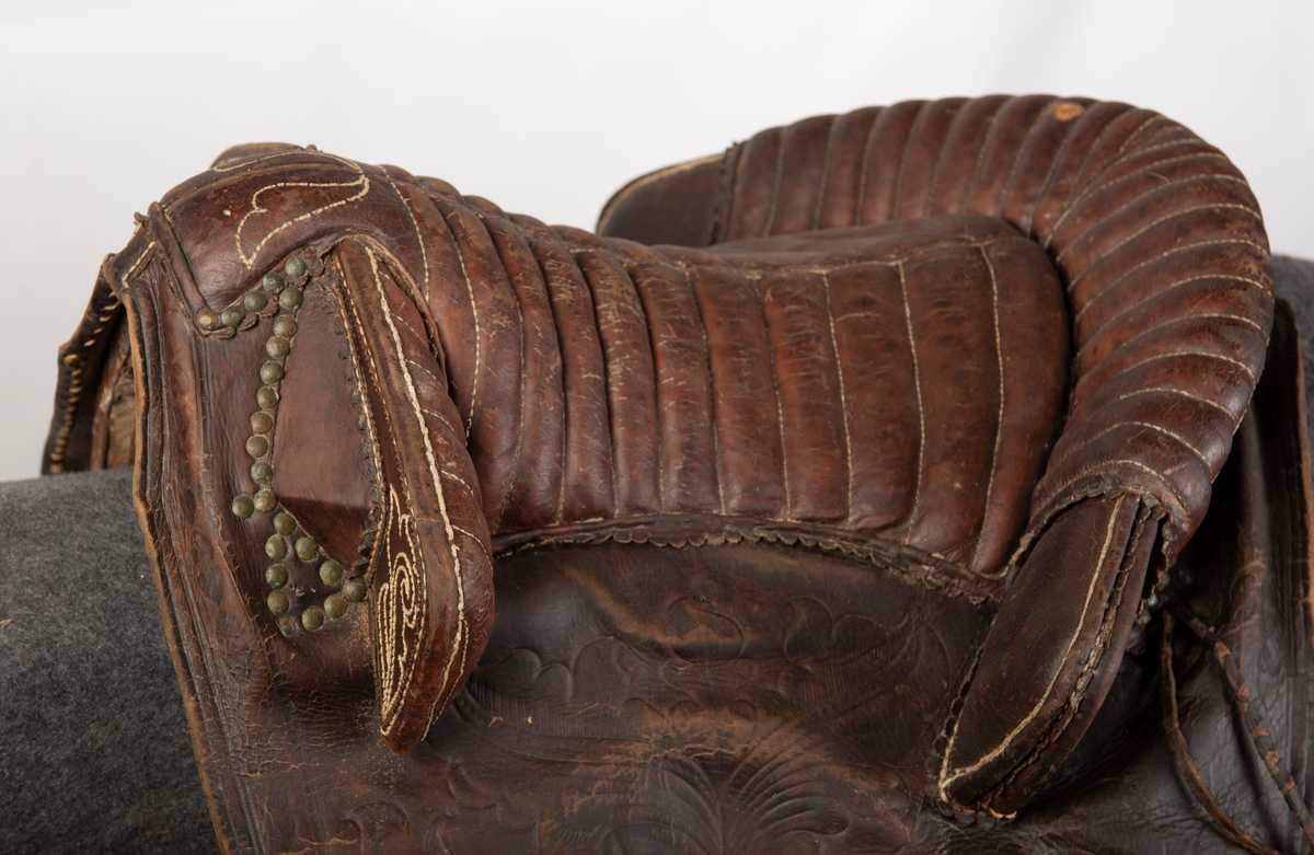 Lærtrukket sadel fra 1778. Initialene ONS brodert. Kapper med preget lær. 