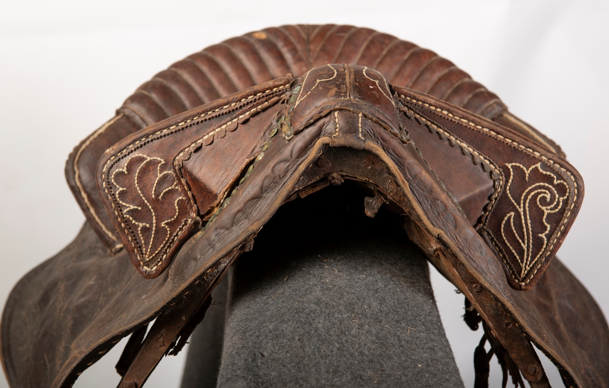 Lærtrukket sadel fra 1778. Initialene ONS brodert. Kapper med preget lær. 