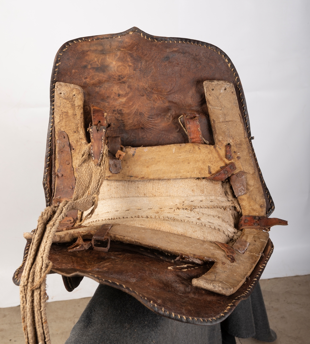 Lærtrukket sadel fra 1778. Initialene ONS brodert. Kapper med preget lær. 