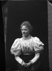 Porträtt av Ester Grönberg. Hon bär en ljus klänning med puf