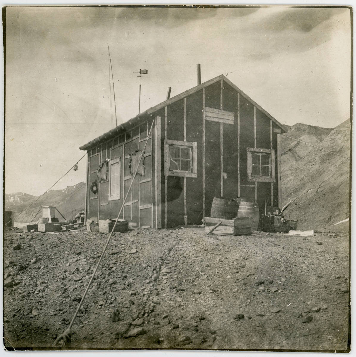 Första svenska antarktisexpeditionens vinterstation på ön Snow Hill. Här tvingades medlemmar ur expeditionen, under ledning av Otto Nordenskjöld, tillbringa vintern 1903 sedan expeditionsfartyget Antarctic förlist. Huset fotograferat av den svenska undsättningsexpedition som anlände den 4 december 1903. Då hade Nordenskjöld m fl redan hunnit räddas av en argentinsk expedition. Påskrift på originalets baksida: "Snow Hill 4/12 1903".