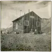 Första svenska antarktisexpeditionens vinterstation på ön Snow Hill. Här tvingades medlemmar ur expeditionen, under ledning av Otto Nordenskjöld, tillbringa vintern 1903 sedan expeditionsfartyget Antarctic förlist. Huset fotograferat av den svenska undsättningsexpedition som anlände den 4 december 1903. Då hade Nordenskjöld m fl redan hunnit räddas av en argentinsk expedition. Påskrift på originalets baksida: 