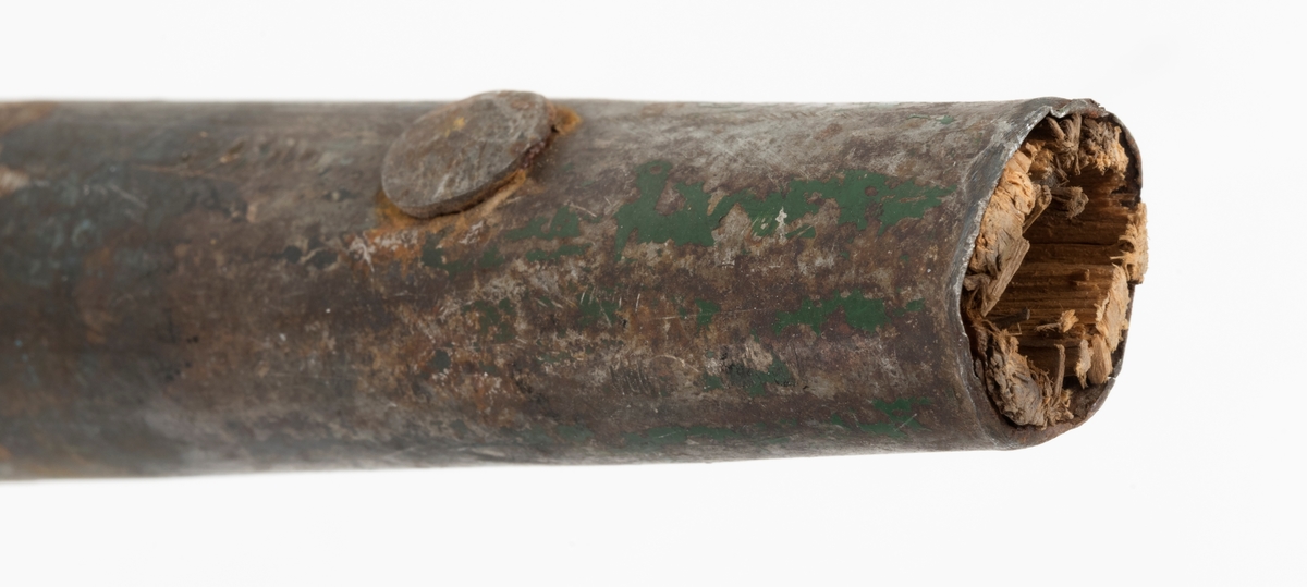 Ladestav, brukt i forbindelse med grøftesprening i skog og utmark, der man forsøkte å drenere vekk vann som virket veksthemmende på produksjonsskogen. Dette redskapet er 109,5 centimeter langt og består av en rett trestav med ovalt tverrsnitt, samt et 36 centimeter høyt sinkgalvanisert endebeslag, ei slags hylse, som omslutter den ene enden av staven. Ettersom denne delen av staven er litt kon, ser det ut til at beslaget egentlig er lagd av to komponenter med litt ulike diametere, Den øverste delen av beslaget har dessuten to sidespalter, som nok er en tilpasning til stavens noe økende tjukkelse fra ytterenden og oppover. Beslaget er forankret i trestaven ved hjelp av to gjennomgående nagler. Rundt den øvre enden av treskaftet er det viklet litt grå tape.