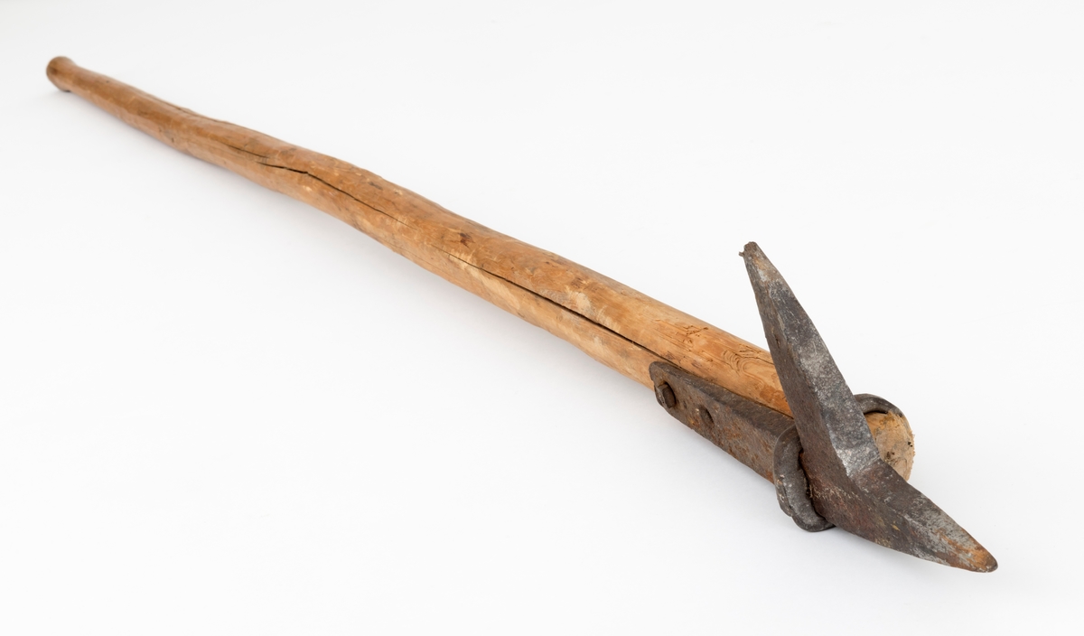 Fløterhake med treskaft. Den smidde haken er 25,1 centimeter lang. Den har en cirka 14,5 centimeter lang og 3,2 centimeter bred flat tange med to gjennombrutte skrue- eller spikerhull. Tangen ligger en mot ei flattelgjet sone ved skaftets fremre ytterende. Her er det festet ved hjelp av en maskinskrue som er ført gjennom det bakre skruehullet og skaftet. Forholdet mellom den fremre delen av tangen og skaftet er stabisert ved hjelp av en smidd jernring som omslutter begge disse komponentene. I forlengelsen av tangen har fløterhaken en framoverrettet, spisst triangulær pigg - i enkelte dialekter kalt «stingar'n» - som er 7,5 centimeter lang. Denne piggen ble brukt når fløterne hadde behov for å bende løs stokker som hadde filtret seg sammen i vassdraget. Haken har også en pigg som står noenlunde vinkelrett på de hittill nevnte komponentene - i noen dialekter kalt «hoggar'n», fordi fløtere hogg denne piggen inn i yteveden på stokkene når de hadde behov for å skyve dem fra seg eller trekke dem mot seg. På dette redskapet er hoggar'n om lag 9 centimeter lang. Spissen er noe oppfliset, og ville vel blitt filt, eller oppvarmet i esse og hamret kvass igjen, dersom haken skulle brukes i praktisk fløting igjen. Skaftet er 137 centimeter langt. Der lagd av stammen fra et undertrykt, seinvokst lite grantre som er barket og overflatebehandlet med kniv. Den smidde haken er festet i rotenden av dette skaftet.