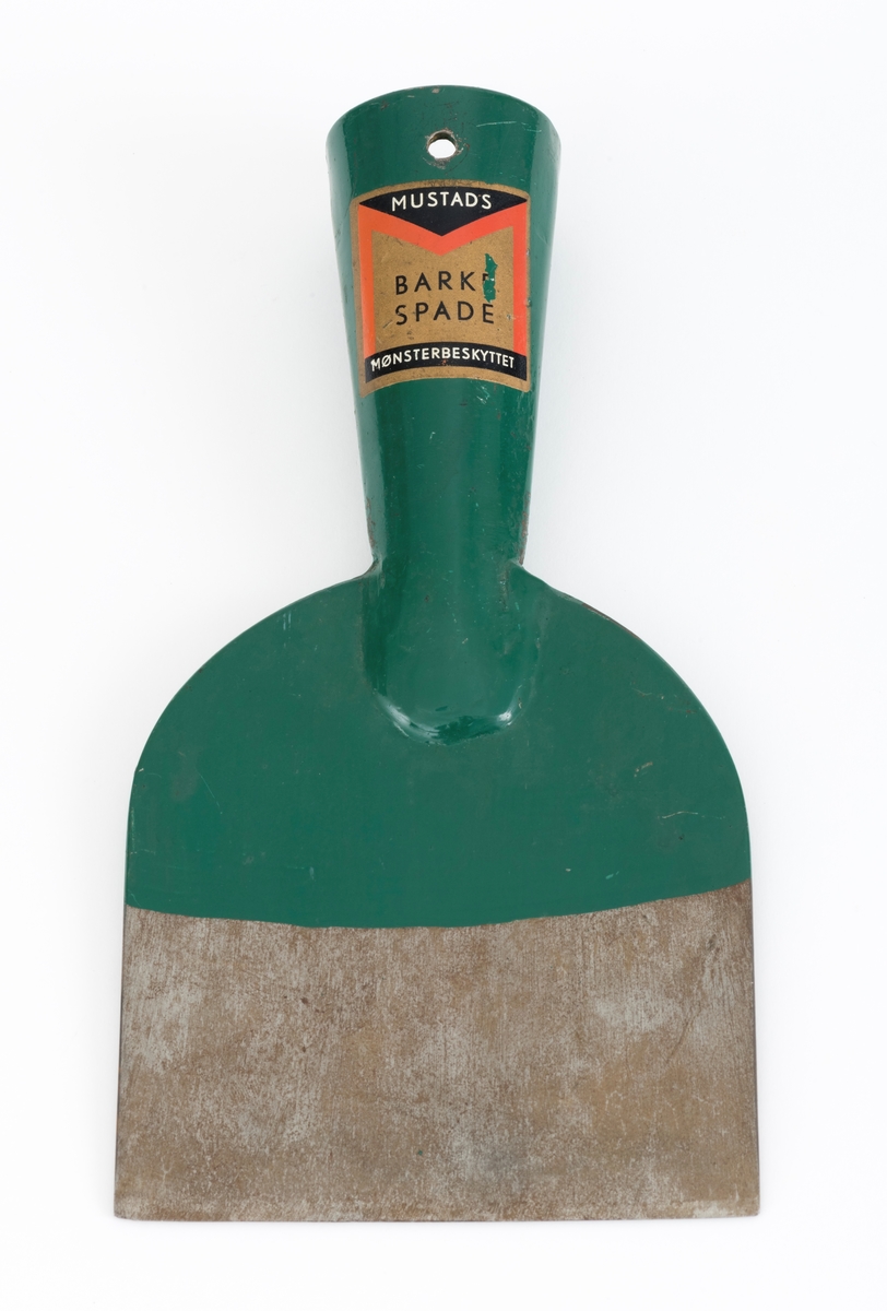 Barkespade fra O. Mustads fabrikker. Barkespaden består av ei plan stålplate med ei påsveiset, kon stålhylse i forlengelsen av bladets midtakse, i overenden.  Bladet er 12 centimeter bredt ved eggen, og egglinja er ubetydelig konvekst buet.  Den øvre enden av bladet var derimot tydelig buet, nærmest halvsirkelformet.  Her er bladet drøyt 4 millimeter tjukt.  Falen er lagd av 3 millimeter tjukt stål.  Den er tilpasset en kjegleformet skaftende og har et gjennombrutt hull med cirka 5 millimeters diameter, antakelig for en skrue eller spiker som skulle forebygge at stålet løsnet fra treskaftet.  Den øvre delen av bladet og falen er innsatt med mørkegrønn lakk.  På falens ytterside er det påsatt en rektangulær etikett med en rød «M» for Mustad på gullfarget og svart botn.  På den samme etiketten finner vi teksten «MUSTADS BARKESPADE MØNSTERBESKYTTET».  Denne barkespaden har ingen nevneverdige slitasjespor som kan tyde på at den har vært brukt i skogen, og den har sannsynligvis aldri vært skjeftet.