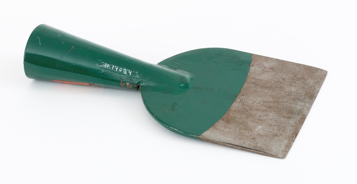 Barkespade fra O. Mustads fabrikker. Barkespaden består av ei plan stålplate med ei påsveiset, kon stålhylse i forlengelsen av bladets midtakse, i overenden.  Bladet er 12 centimeter bredt ved eggen, og egglinja er ubetydelig konvekst buet.  Den øvre enden av bladet var derimot tydelig buet, nærmest halvsirkelformet.  Her er bladet drøyt 4 millimeter tjukt.  Falen er lagd av 3 millimeter tjukt stål.  Den er tilpasset en kjegleformet skaftende og har et gjennombrutt hull med cirka 5 millimeters diameter, antakelig for en skrue eller spiker som skulle forebygge at stålet løsnet fra treskaftet.  Den øvre delen av bladet og falen er innsatt med mørkegrønn lakk.  På falens ytterside er det påsatt en rektangulær etikett med en rød «M» for Mustad på gullfarget og svart botn.  På den samme etiketten finner vi teksten «MUSTADS BARKESPADE MØNSTERBESKYTTET».  Denne barkespaden har ingen nevneverdige slitasjespor som kan tyde på at den har vært brukt i skogen, og den har sannsynligvis aldri vært skjeftet.