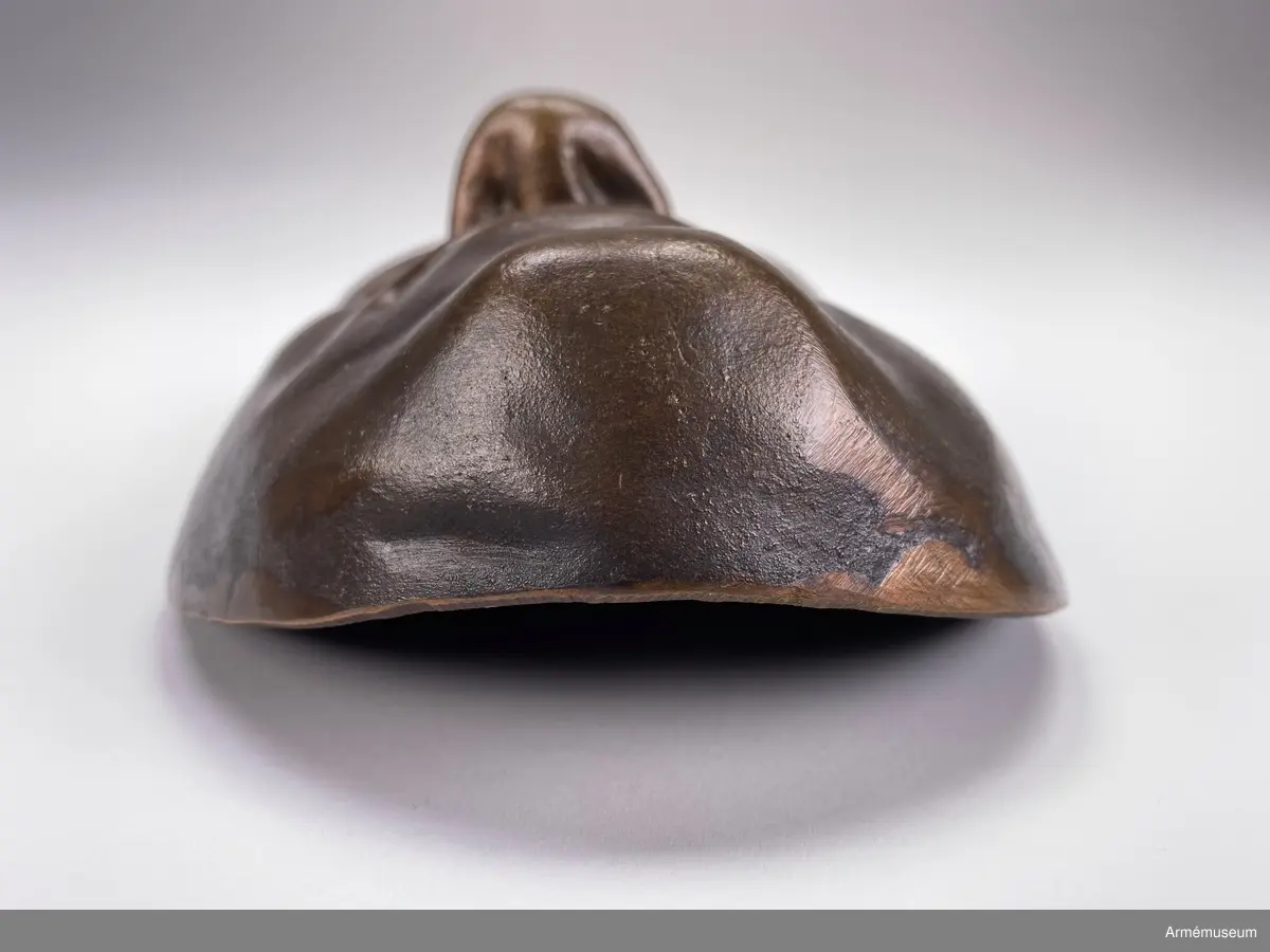 Bronsmask föreställande den döde Karl XII.

Enl styresman Olle Cederlöfs anteckningar med anledning av gåva AM.066063 (AM 73/475) är detta inte en dödsmask. 

"Proportionerna i ansiktet stämmer inte med kraniets proportioner enl 1918 års gravöppning - utan en av den schweiziske medaljgravören Hedlinger gjord frihandsmodellering inför konungens lik på Karlberg 1718. Hedlingers modell nu endast avsedd att ligga till grund för hans uppdrag: Att modellera en reliefbild för konungens mynt och minnespenningar. Hedlinger anlände till Sverige 1718-. Konungen hade då avlidit och Hedlinger hade aldrig sett Karl XII i levande livet, han tog chansen att fånga konungens ansikte inför 'lit de parade' på Karlberg. Hedlingers 'dödsmask' har senare avgjutits i gips, brons och  järn i olika sammanhang."