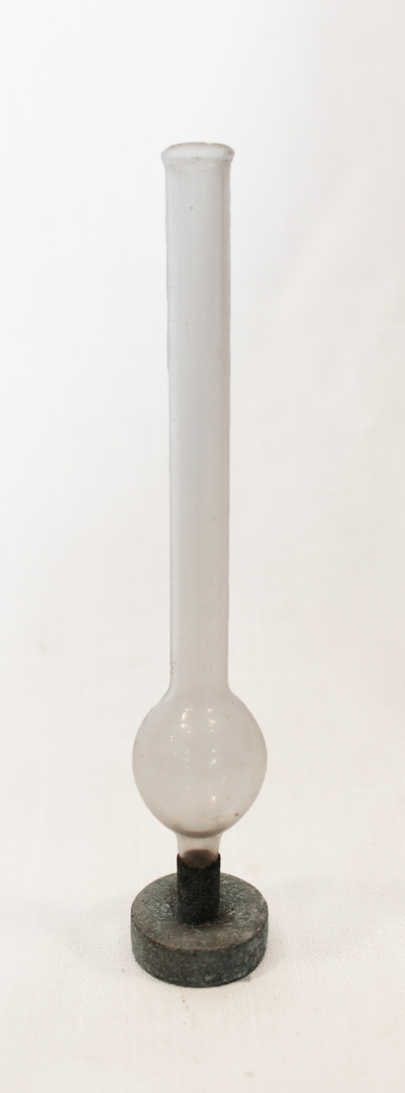 Målekolbe med graderinger, fra 0 til 12, i glasset. Foten er av kobber.