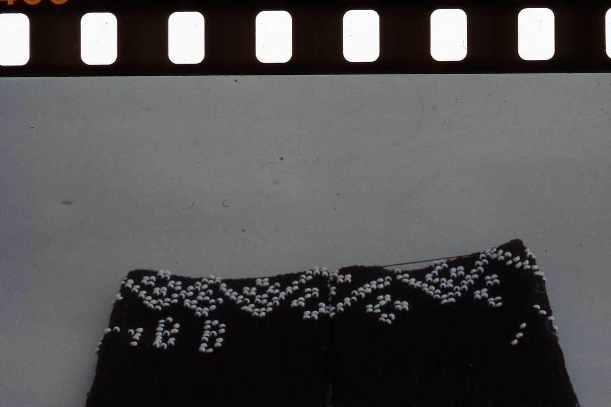 I början av 1800-talet kom pärlor att användas i stickning. Det var modernt i högreståndshem, där man stickade små väskor.

Muddar i ullgarn med instickade pärlor blev modernt hos allmogen i mitten av 1800-talet. Då blev tunna stålstickor och färgade glaspärlor billigare och mer lättillgängliga. Mönster hämtades från märkduksbroderiernas korsstygnsmönster som var lätta att överföra till pärlstickning. Muddarna var som smycken men värmde också handlederna.

I Jämtland och Härjedalen finns flera fina pärlstickade muddar bevarade.

Fotot (bild 4) föreställer Anna Helena Björkebaum.

/Ingela Fredell, 2024-03-26