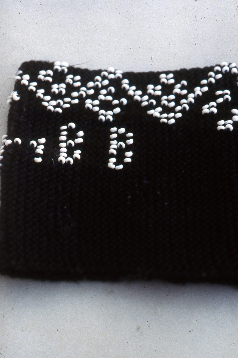 I början av 1800-talet kom pärlor att användas i stickning. Det var modernt i högreståndshem, där man stickade små väskor.

Muddar i ullgarn med instickade pärlor blev modernt hos allmogen i mitten av 1800-talet. Då blev tunna stålstickor och färgade glaspärlor billigare och mer lättillgängliga. Mönster hämtades från märkduksbroderiernas korsstygnsmönster som var lätta att överföra till pärlstickning. Muddarna var som smycken men värmde också handlederna.

I Jämtland och Härjedalen finns flera fina pärlstickade muddar bevarade.

Fotot (bild 4) föreställer Anna Helena Björkebaum.

/Ingela Fredell, 2024-03-26