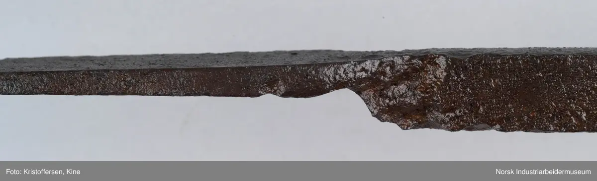 Denne gjenstanden er funnet i ett eller annet av jernbanens bygg. Gjenstanden framkommer som hel og fin og i god stand. Den har ingen slitasjemerker. Det er umulig å si om det har vært spiker eller skruer gjennom hullene og om den dermed har vært hengt opp eller festet på noen måte. Lengden på hele gjenstanden er 81 cm. Det er en skjøt på skaftet, som tyder på at to deler er sveiset sammen. Gjenstanden er forsiktig konservert foran utstillingen på Rjukan stasjon, det vil si at den er pusset med fint sandpapir og har fått et tynt lag voks. 
Ingen vet hvor den kommer fra, hvor den hører til eller hva den har vært brukt til.