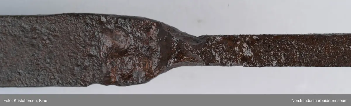 Denne gjenstanden er funnet i ett eller annet av jernbanens bygg. Gjenstanden framkommer som hel og fin og i god stand. Den har ingen slitasjemerker. Det er umulig å si om det har vært spiker eller skruer gjennom hullene og om den dermed har vært hengt opp eller festet på noen måte. Lengden på hele gjenstanden er 81 cm. Det er en skjøt på skaftet, som tyder på at to deler er sveiset sammen. Gjenstanden er forsiktig konservert foran utstillingen på Rjukan stasjon, det vil si at den er pusset med fint sandpapir og har fått et tynt lag voks. 
Ingen vet hvor den kommer fra, hvor den hører til eller hva den har vært brukt til.