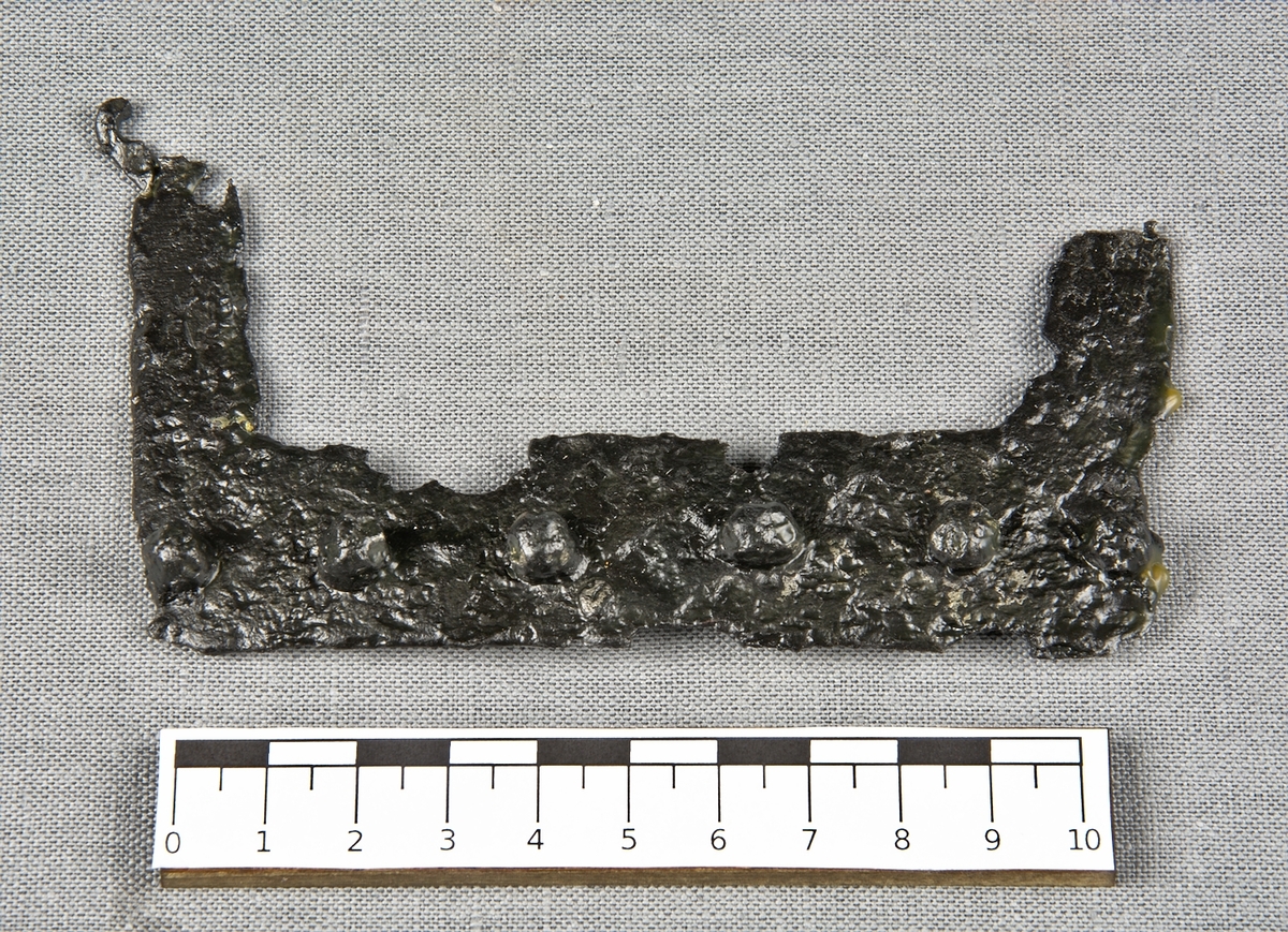 Beslag av järn med 6 stycken kvarsittande spikhuvuden.