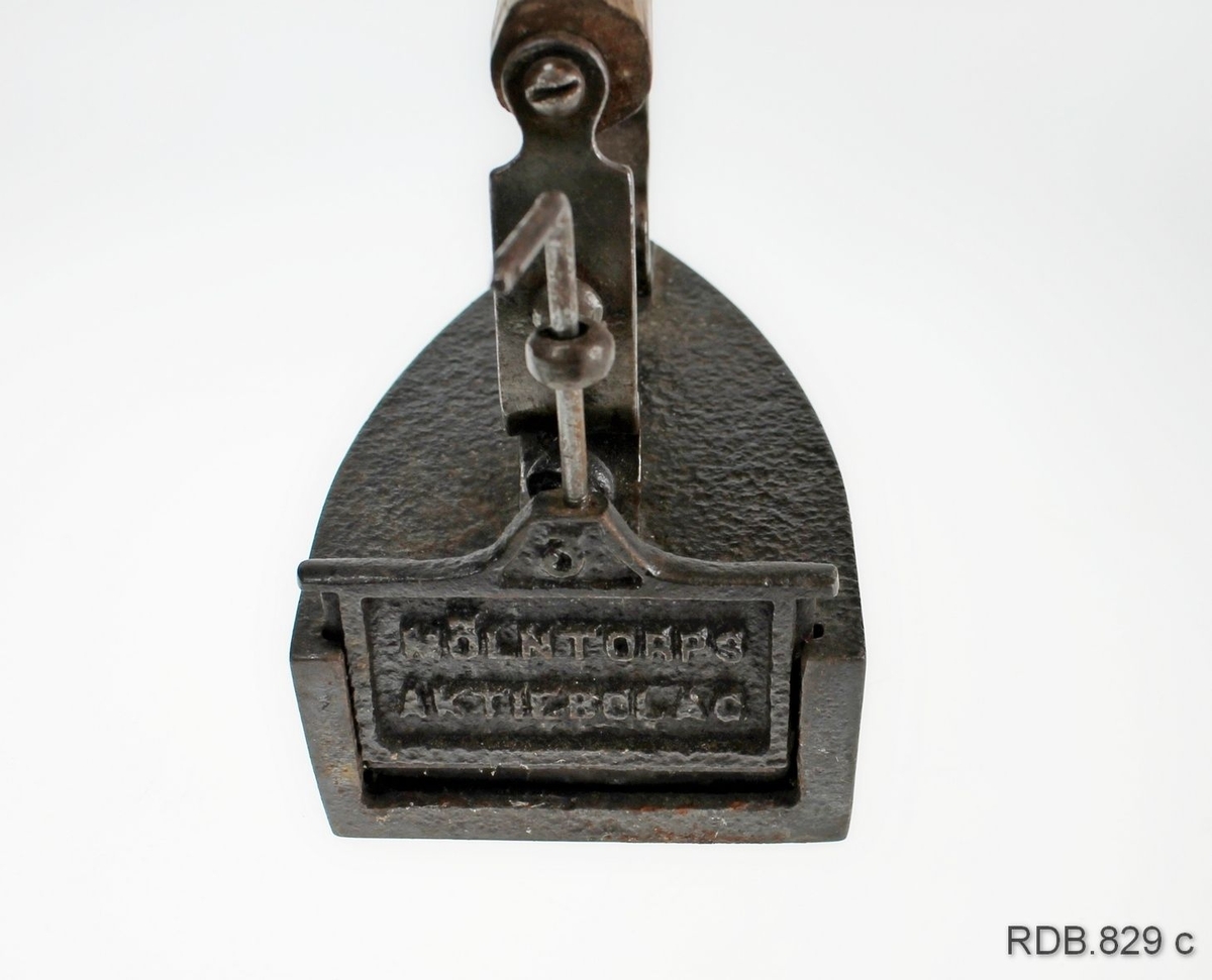 Strykejern i støpt jern. Jernet er innhult med rom for en stein/bolt som kan tas ut og varmes på ovnen. I bakkant på strykejernet er det en luke som går i et spor og som kan løftes opp, slik at steinen kan tas ut/settes inn. Et handtak i tre er festet med skruer til to jern-"stenger" som er festet med skruer til selve jernet. Innstøpt på luka: Mølntorps aktiebolag.