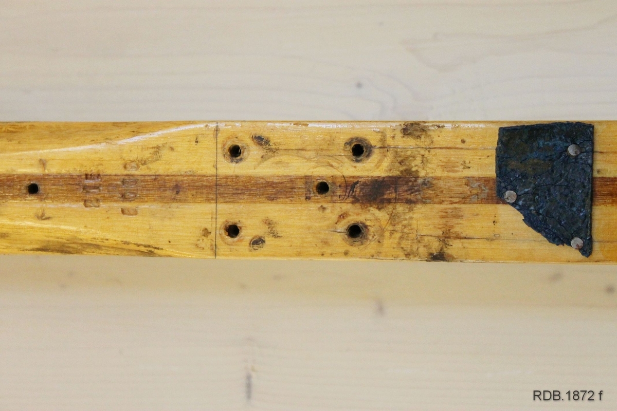 Avsmalende jevnbred ski med liten bue. Bøy uten tupp. Tilspisset brettende.
Dekorert med ei brun stripe på trehvit bunn.

Stempel fra 1960-sesongen på skiet.
