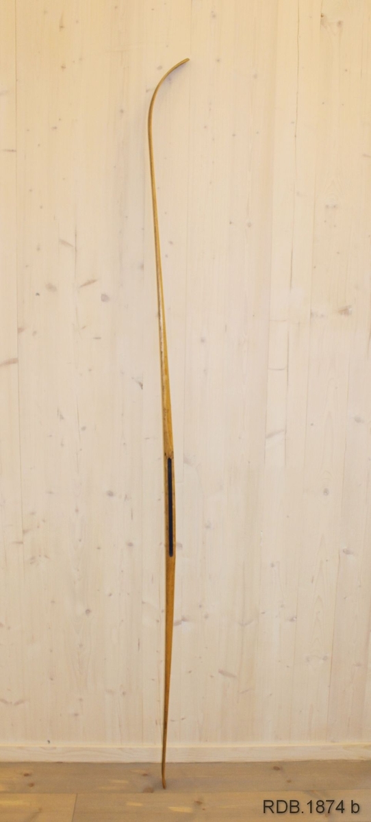 Avsmalende, jevnbred ski med liten bue. Bøy uten tupp. Rett avskåret bakende.
Dekorert med ei brun stripe på trehvit bunn.

Noen stempel fra OL øverst på skiet.