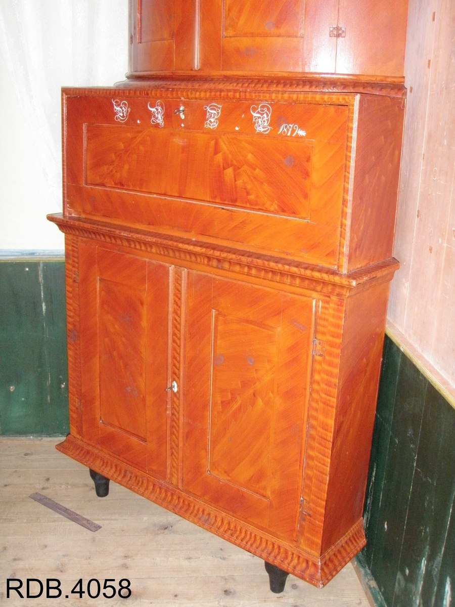 Dette er et kråskap malt i rødt. Det har tre rom, hvor det øverste og nederste er de største. Det øverste rommet har en avrundet front, og to dører. Innvendig har det en hylle, samt en rekke med 12 hakk som man kan henge skjeer osv. i. Rommet er malt med en hvit grunnfarge og noen brune flekker som er lasert på. Dørenes innside er rosa. Det midterste rommet er minst. Det har en firkantet front, og også fremste del av sidene er firkantet. Det har en dør som er hengslet i nerkant. Når den åpnes, faller fren framover og blir som et bord. På utsiden av denne døra er det påskrevet dette; RNDB 1879. RNDB står for Rannei Nilsdatter Bjørnstad. Det midterste rommet er trehvitt, men døras innside er malt rosa. Det nederste rommet har en firkantet front og firkantede sider helt fremst. Rommet har en hylle. Den er trehvit, men kanten på fronten av den, er malt med samme lasering som skapet ellers. Rommet har to skapdører som slås utover. Innsiden av skapdørene er rosa, mens resten av rommet er trehvitt. Alle tre rommene har nøkkellås i dørene, og alle tre nøklene eksisterer fortsatt på kråskåpen. Skapet står på tre føtter; to i front og en i bakerste hjørne.Skapet er lasert med en brunrød farge.