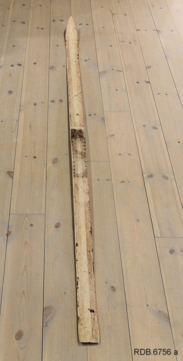 Et heimeprodusert treski. Sålen på skiet er borte, slik at en kan se hvordan det er laget invendig. Overplata har mørke striper langs kanten og en lys stripe etter midten. Skiet er jevnbredt med tverr bakkant, bred brett med lav bøy. Skiet er bredest på midten og smalere bak- og framover. Spikermerker etter bindinger og fotplate som er fjernet. Innvendig er det 4 "luftrom" som gjør skiet lettere.