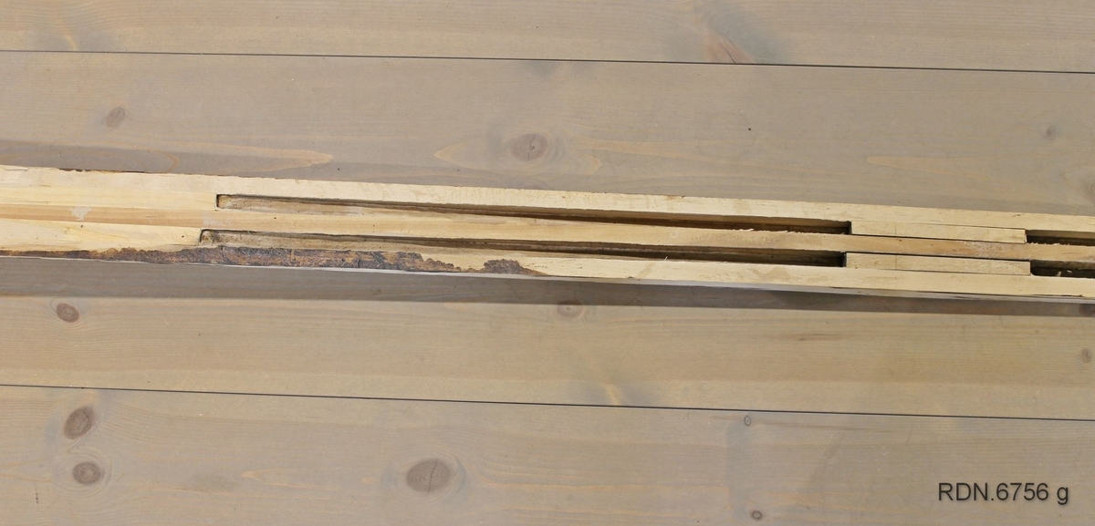Et heimeprodusert treski. Sålen på skiet er borte, slik at en kan se hvordan det er laget invendig. Overplata har mørke striper langs kanten og en lys stripe etter midten. Skiet er jevnbredt med tverr bakkant, bred brett med lav bøy. Skiet er bredest på midten og smalere bak- og framover. Spikermerker etter bindinger og fotplate som er fjernet. Innvendig er det 4 "luftrom" som gjør skiet lettere.