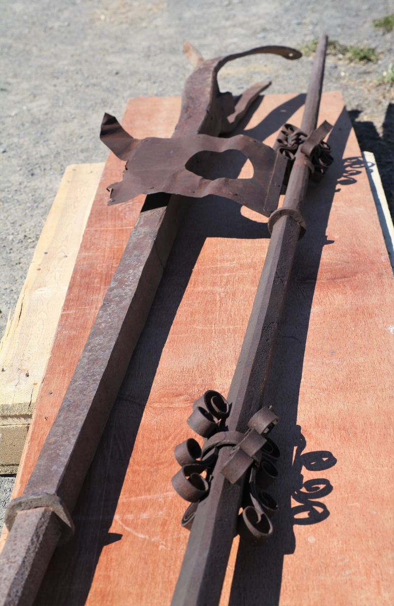 Nederste del av spiret til Aas kirke. Jernstang med tre kjør i den ene enden.