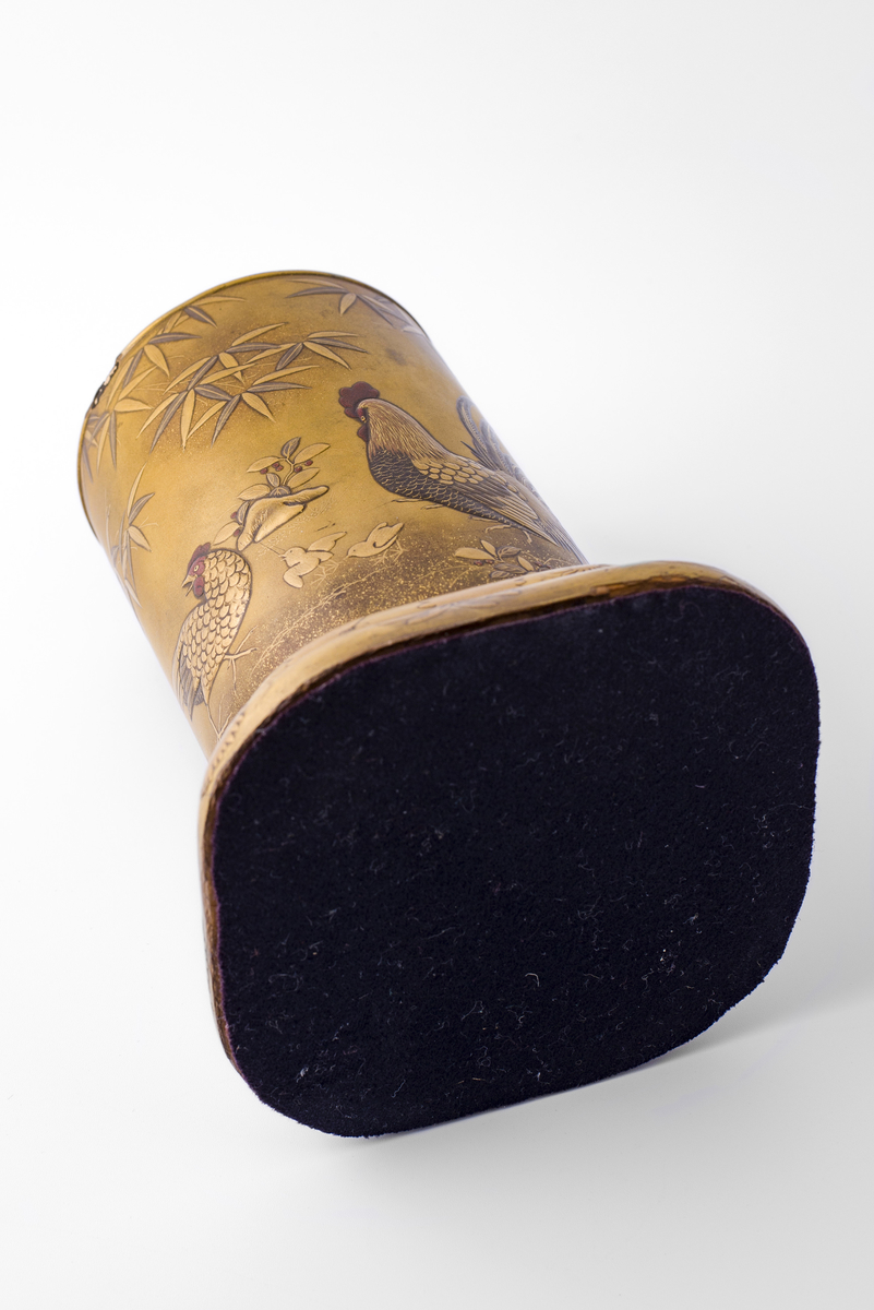 Rund vase av bambus (?) på avrundet, firkantet sokkel. Malt, lakkert eller glasert i relieff med motiv av bambus, blomster, hane, høne, orientalsk landskap.