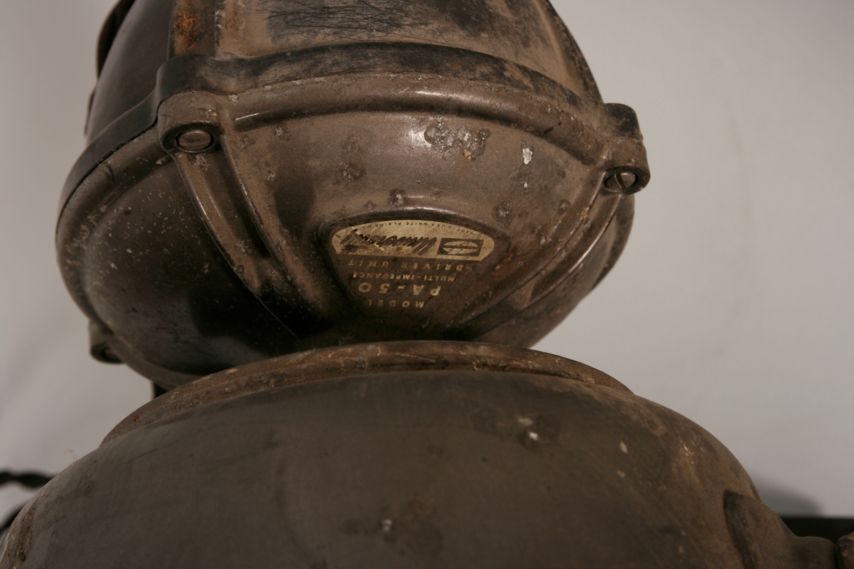 Fire høytalere i metall. Oppheng i metall, med strømkåpe av kunststoff og ledning trukket av tekstil.
Nedre kant på klokkestykket i beskyttende gummi.