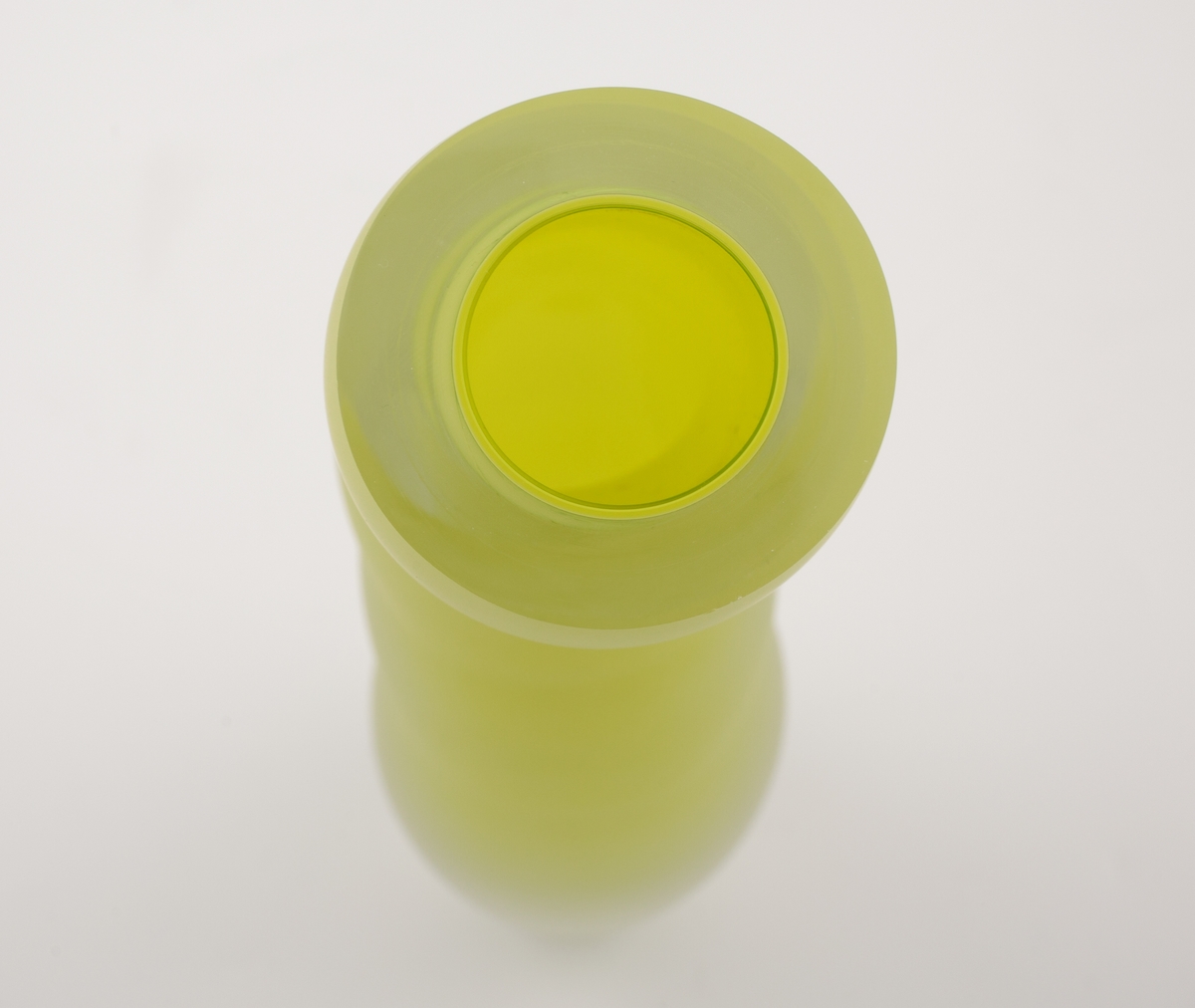 Vase i underfangsglass. Et sjikt i opakt grønnfarget glass innerst, deretter et tykt sjikt i klart glass. Flerleddet kuleformet korpus, hvis ytterside er mattet ved hjelp av sandblåsing. Vasens sirkulære munning er planslipt.