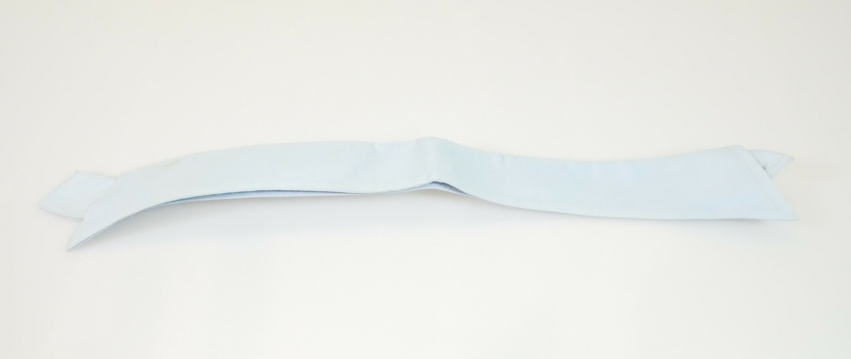 Blå løskrage i bomull til herredrakt. Kragen er brettet. Den innerste delen av kragen har knappehull i begge endene og et knappehull midt på bakerst på kragen. Den ytterste delen av kragen har spisse kanter. 