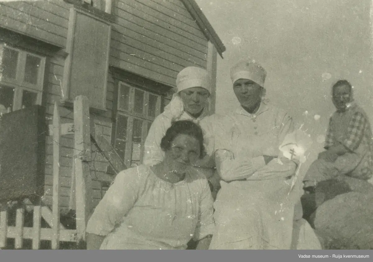 Kvinner i sykepleieuniformer poserer i solen foran Kistrand pleiehjem i Porsanger, Finnmark. 1920-1925.