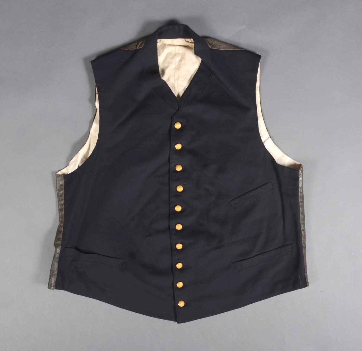 Metall hatteeske med hengslet lokk. Håndtak på lokket og en hempe på siden for hengelås. Esken har ikke fôr.
Hatten i silkefloss, er to snutet med gullbånddekor på hver snute. Langs kanten på den oppbøyde bremmen er det sydd på ripsvevd silkebånd. På den ene siden er det en kokarde med norske farger. Over denne ligger det gullbånd (krampe) festet til en gullfarget knapp med motiv anker. Hatten har fôr og svettebånd med en sløyfe. Det er stempel inne i pullen. To små knapper er sydd fast i pullen Rundt disse er det viklet snor. Hatten har hakebånd med spenne.