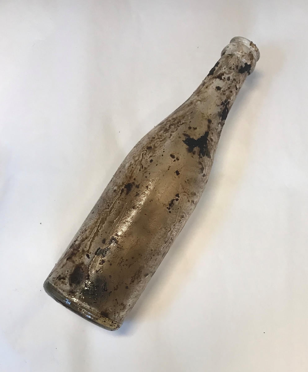 Rifle, et par gummistøvler, arbåndsur, tekstilrester, lommelykt, insulinsprøyte i metallrør, penn, kniv, slire, 13 mynter, en plastbit, hanske, 2 små glassflasker og en stor glassflaske.