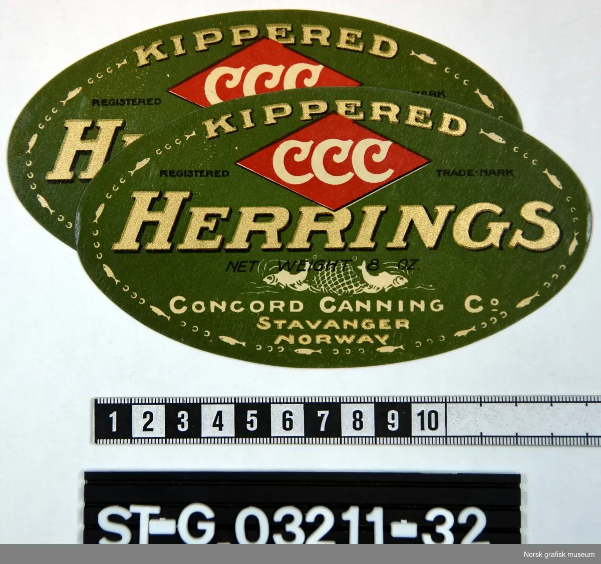 To stk. ovale etiketter i grønt, rødt, hvitt og gull. Ytterkanten er omkranset av en bord laget av fisk og bokstavene (varenavnet) CCC. 

"Kippered Herrings"
