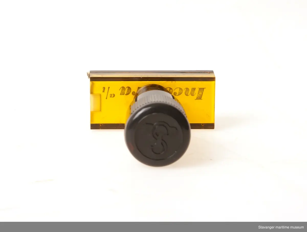 Stempel i plastikk og glass, hvor det står Incentra A/l Kontrakt med et øye over.