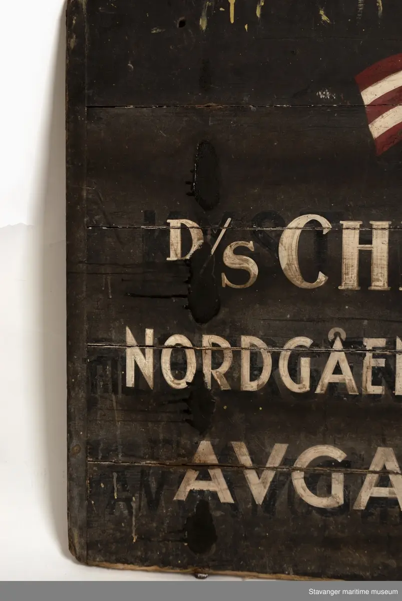 Svartmalt treskilt med påmalt DSD, postflagget og rutefartinformasjon.