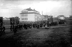 Stationskarl Erikssons begravningsprocession med standar i teten passerar Töreboda skola 1926.
