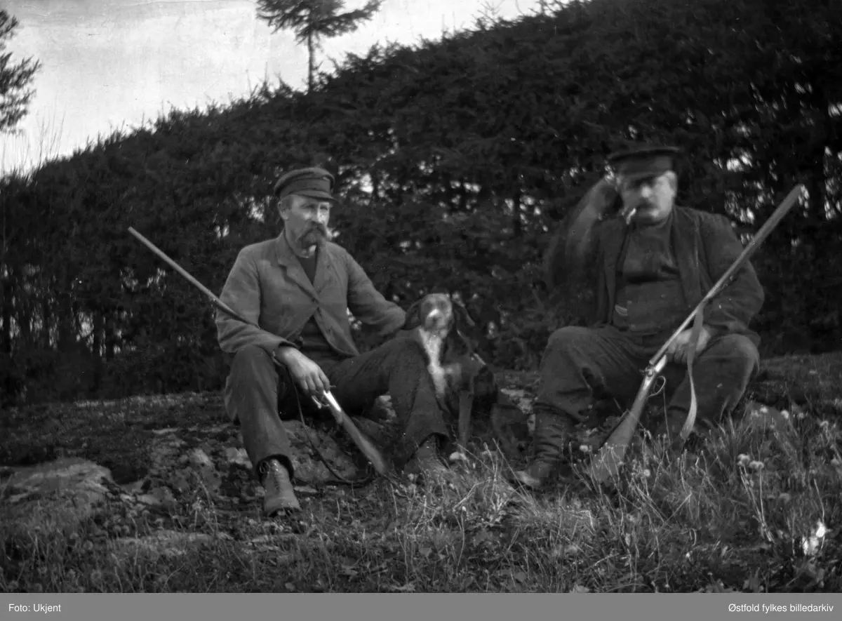 På jakt i Trøgstad ca. 1920. Jegerne er skomaker Nikolaisen og Hans Henningsmoen med hunden.