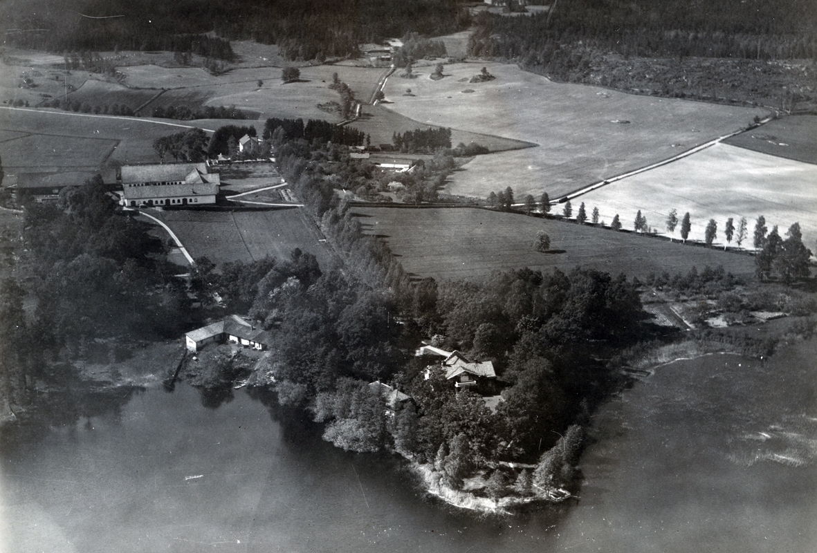 Flygfoto över Sundsholms säteri i Gladhammar. Vy på säteriet med ekonomibyggnader och åkrar samt sjön Maren.
