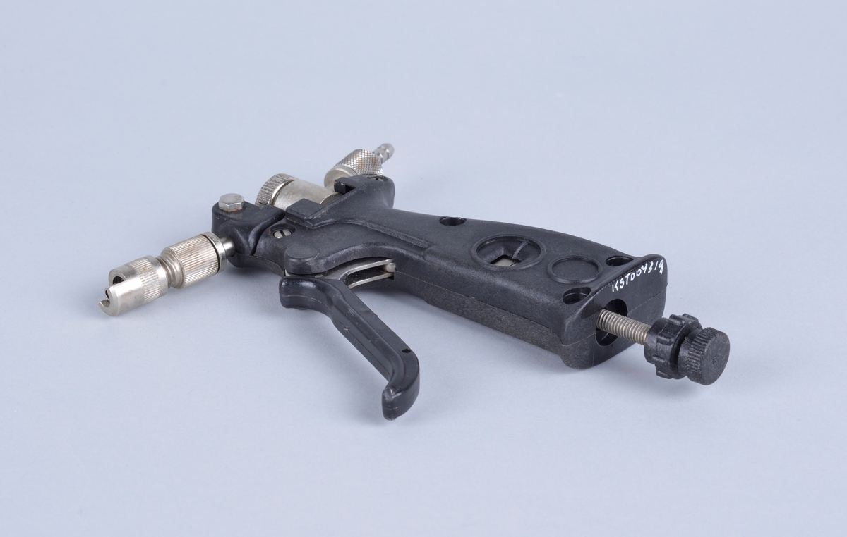 Vaksinepistol av merket Rapi-Vacc.
Automatisk multi-dose vaksinator. 
Hver dose er fra 0 - 1,0 ml
Med pistolen følger en tynn hvit gummislange med injeksjonsnål (?), Ventilasjonsrør (?) samt det som trolig er ulike reservedeler. 

Vedlagt brosjyre fra leverandøren og brev fra Proffesor Tore Håstein