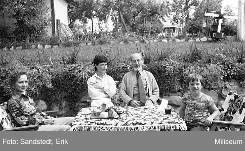 Familj vid ett bord. Erik Sandstedt trea från vänster. Dalgången 8.