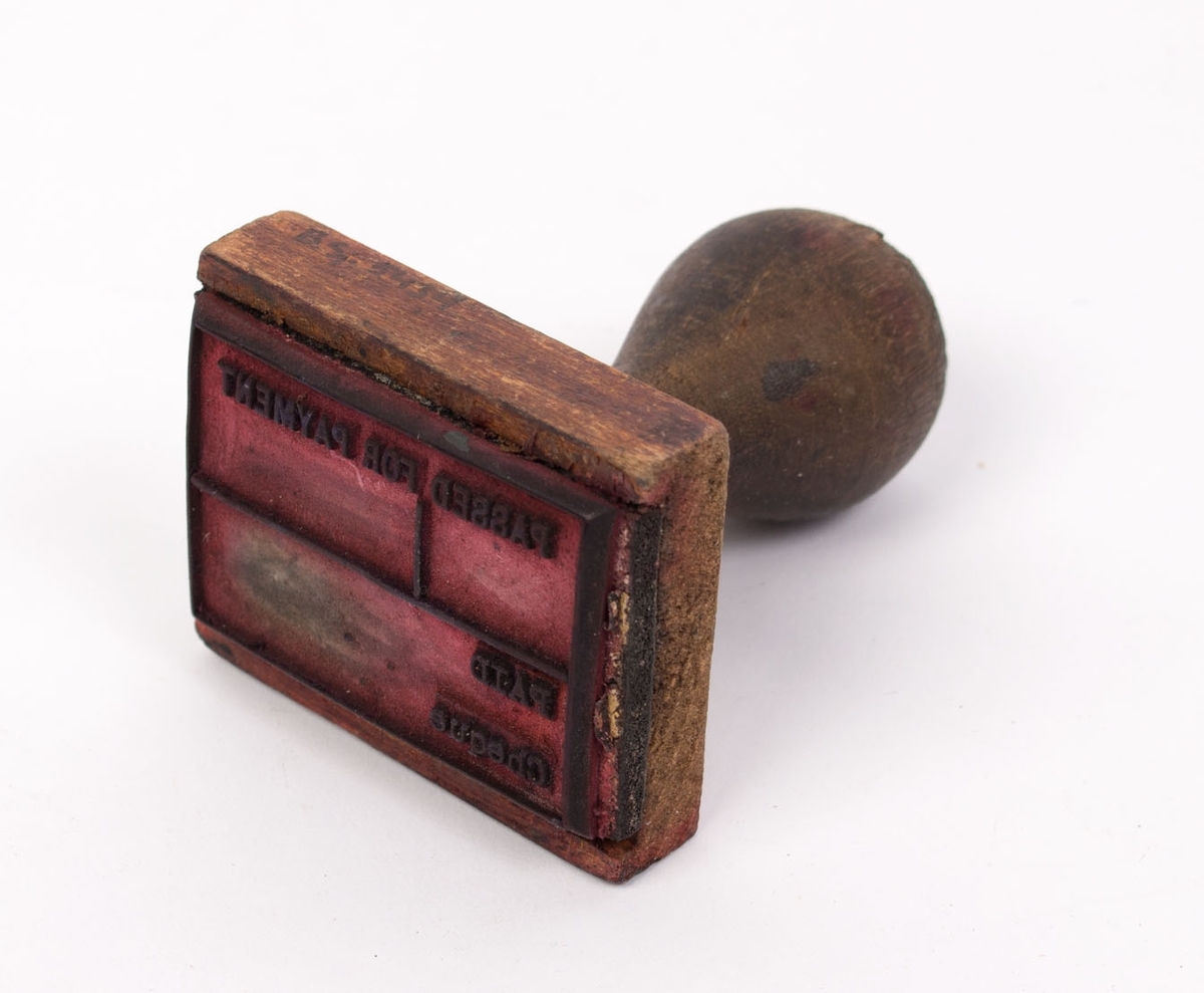 Stempelsamling fra Englandskontoret. Smalt, rektangulært stempel med stempelpute og dreid håndtak.