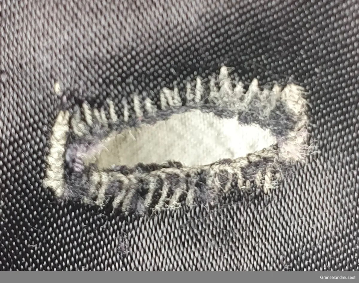 Sprt forkelkjole. Sydd av kåpefor. Bølankt stoff, muligens viskose (kunstsilke). Maskinsydde sømmer, Sårkanter overkastet med hånd. Håndsydde knapphul. Knappene fra kåpa.