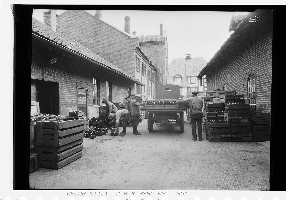 Byggeriarbeidere setter ølkasser på bil. Lillehammer Bryggeri. Fotografert 1927.
