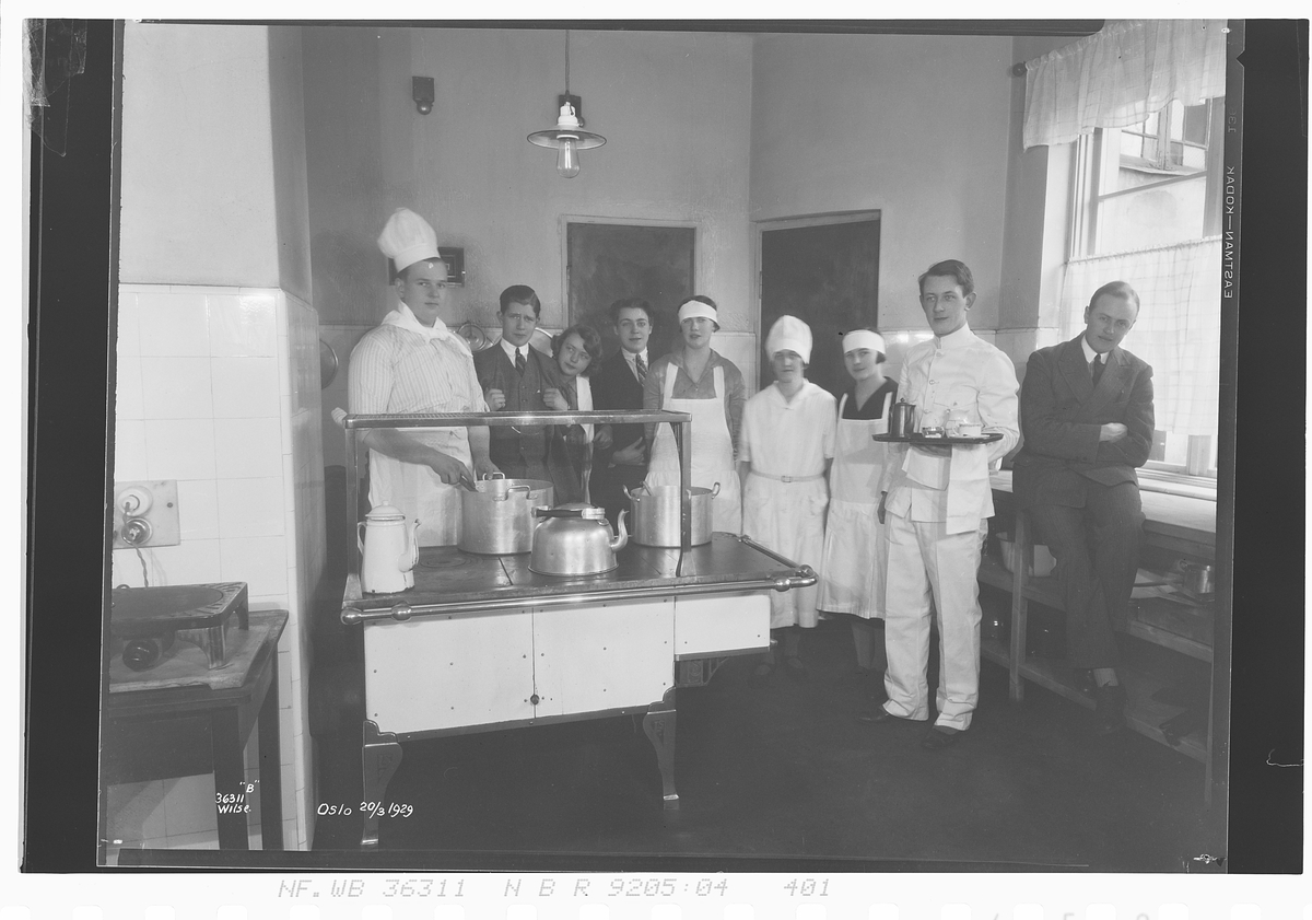 Elver og kokk ved komfyr, Norsk hotellfagskole. Fotografert 1929.