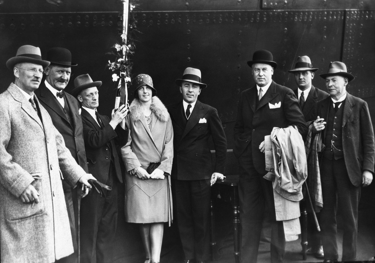 Kvinne og menn klar for dåp av skipet Kosmos.