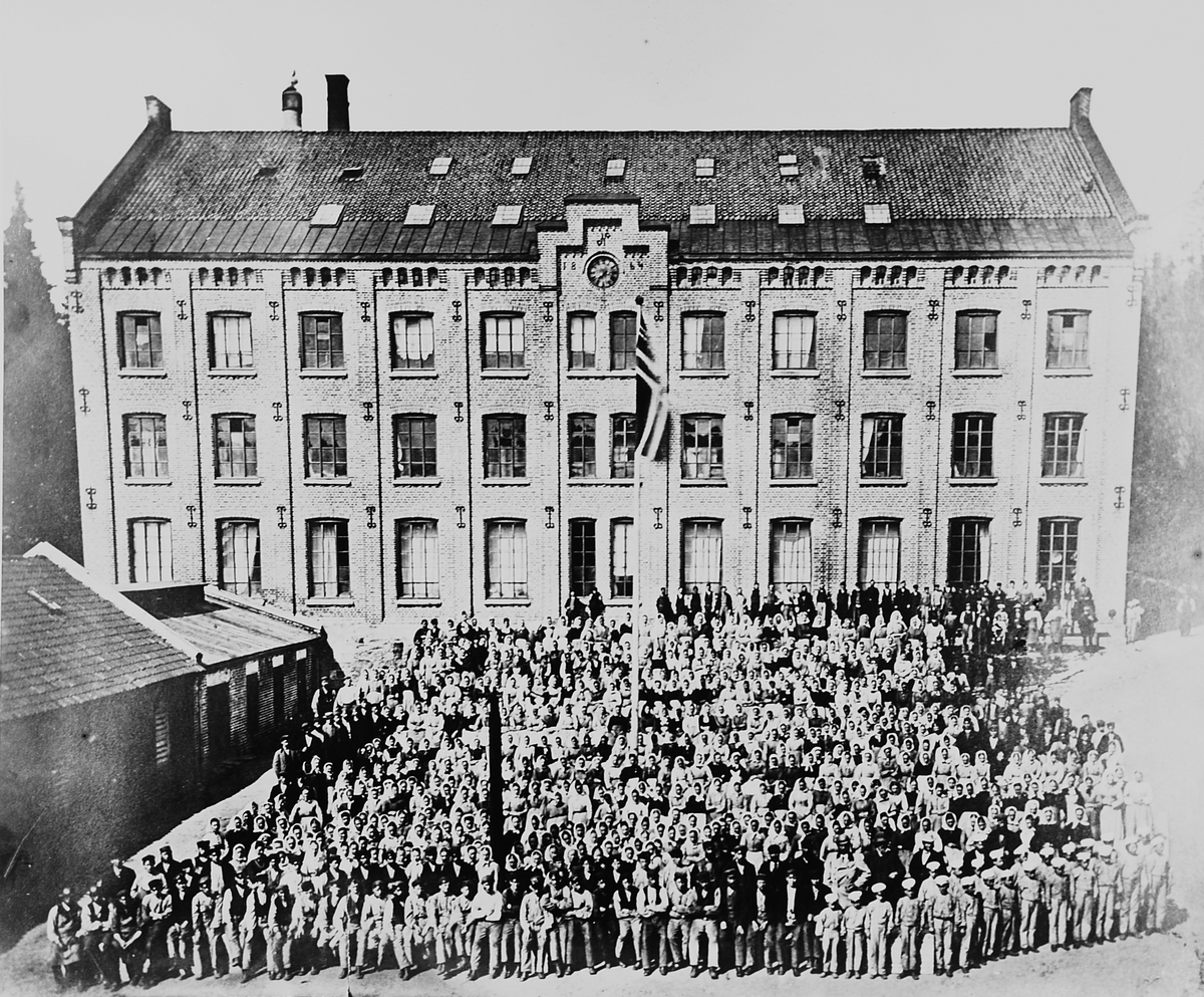 Antatt fabrikkbygning med de ansatte utenfor. Usikker: Betzy Kjelsberg-bygning.