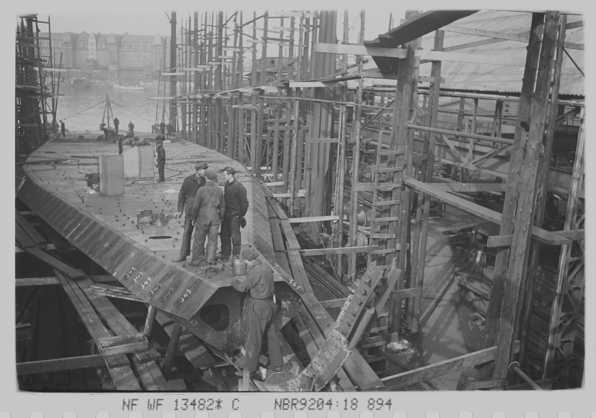 Skipsbygging på Nylands verksted. Havnelageret i bakgrunn. Oslo. Fotografert 1940.