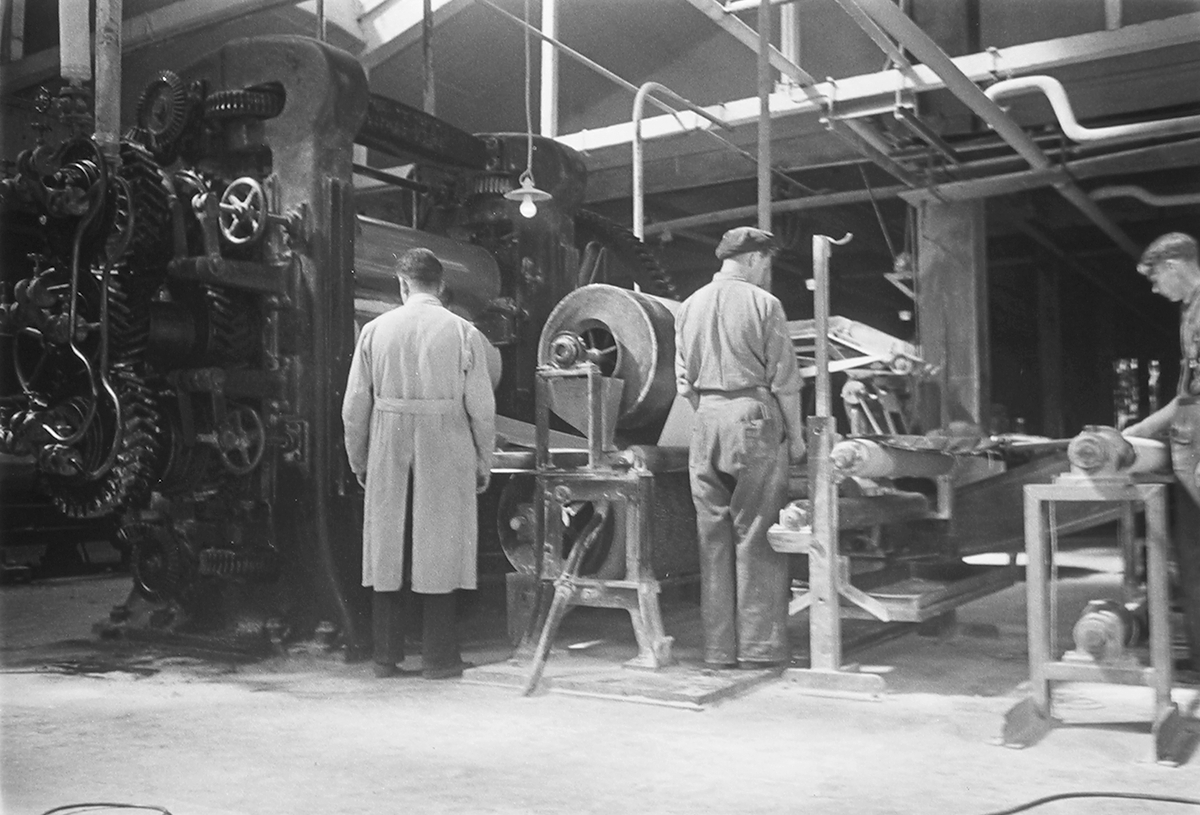 Ansatte i produksjonshallen. Den Norske Kalosje- & Gummivarefabrikk A/S, senere Mjøndalen Gummivarefabrikk, Eiker. Fotografert 1940.